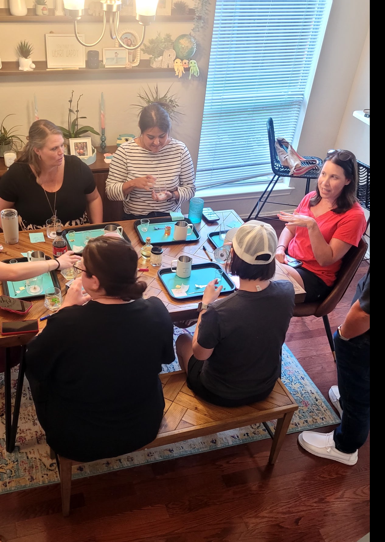 Guests gathered around a candle-making table with trays and scent supplies