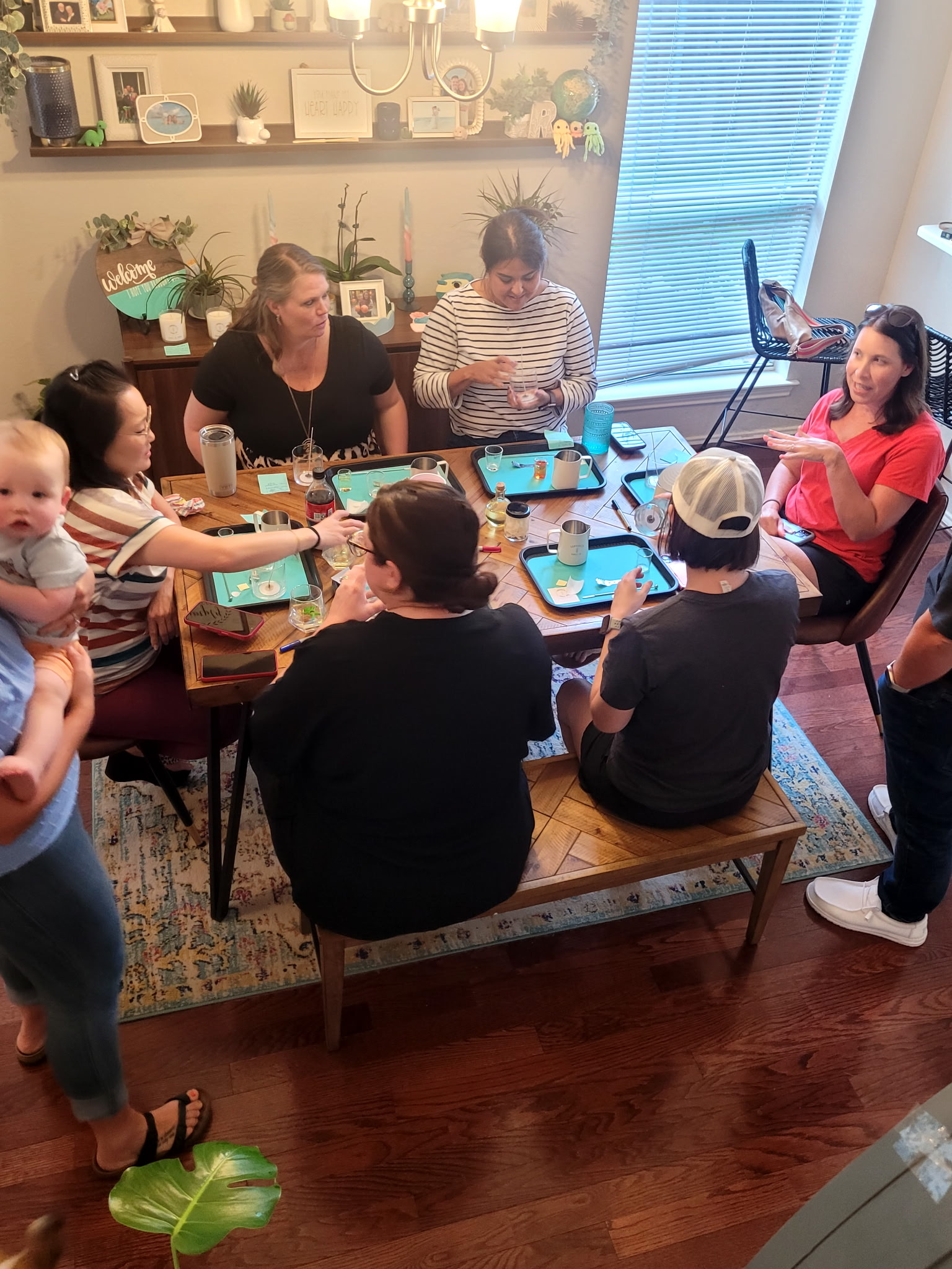 Guests gathered around a candle-making table with trays and scent supplies