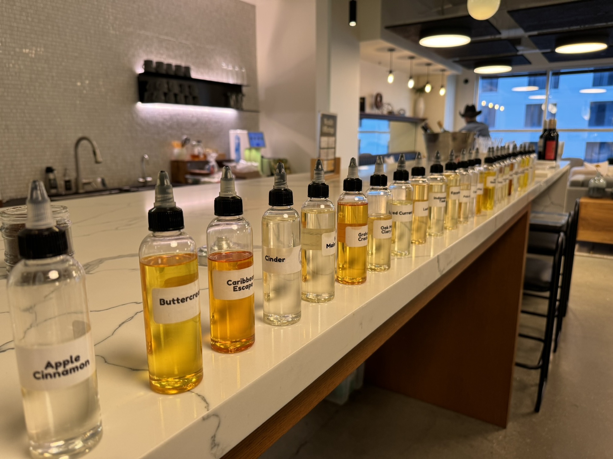 Rows of fragrance oil bottles prepared for a candle-making class